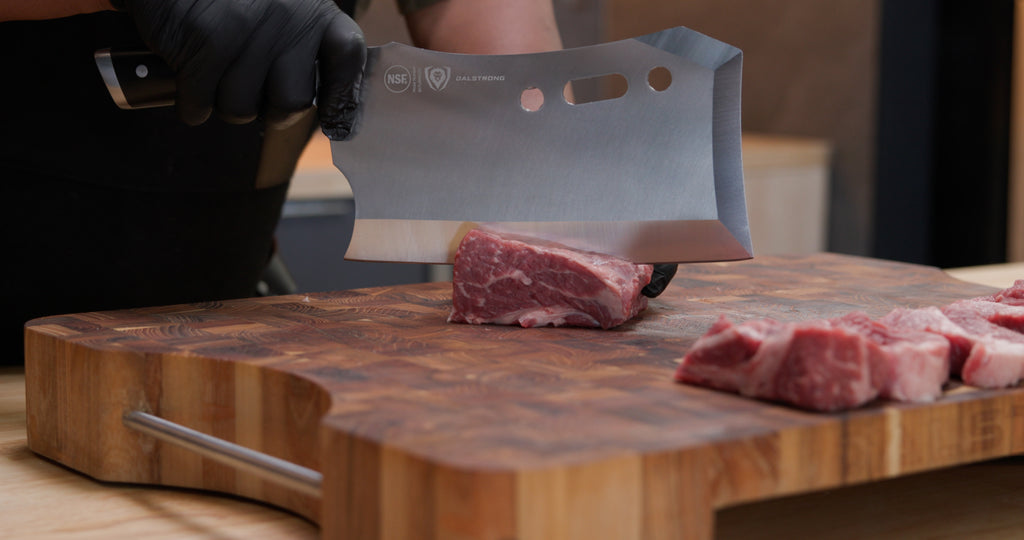 A man chopping meat using the Gladiator Series R Meat Cleaver 9" with Stand