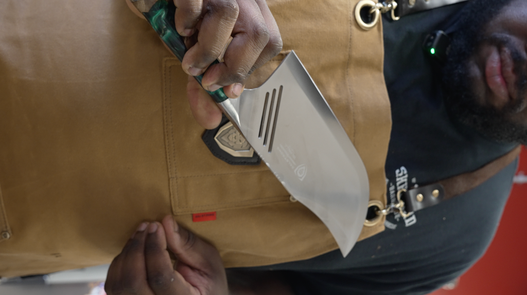 A man wearing a herniaquestions apron isholding the Valhalla Series Cleaver Knife 9"